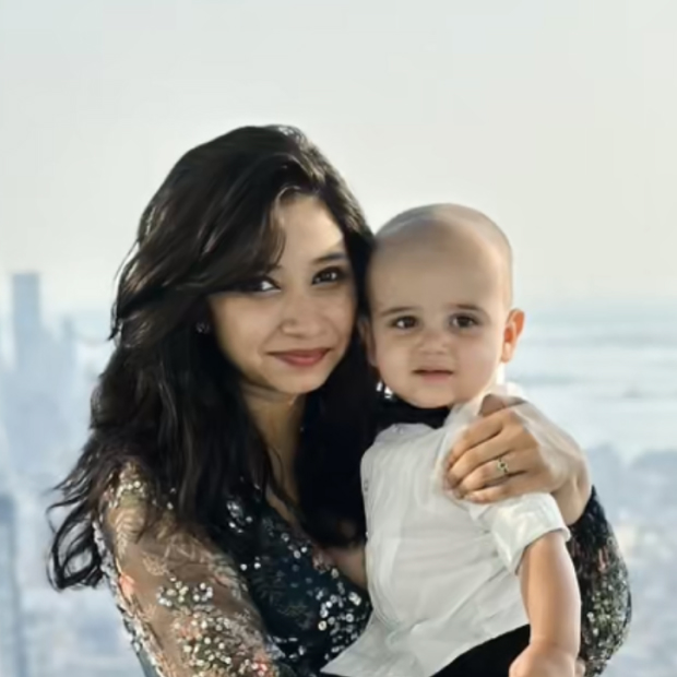 Nandhita and her child against a light outdoor background.
